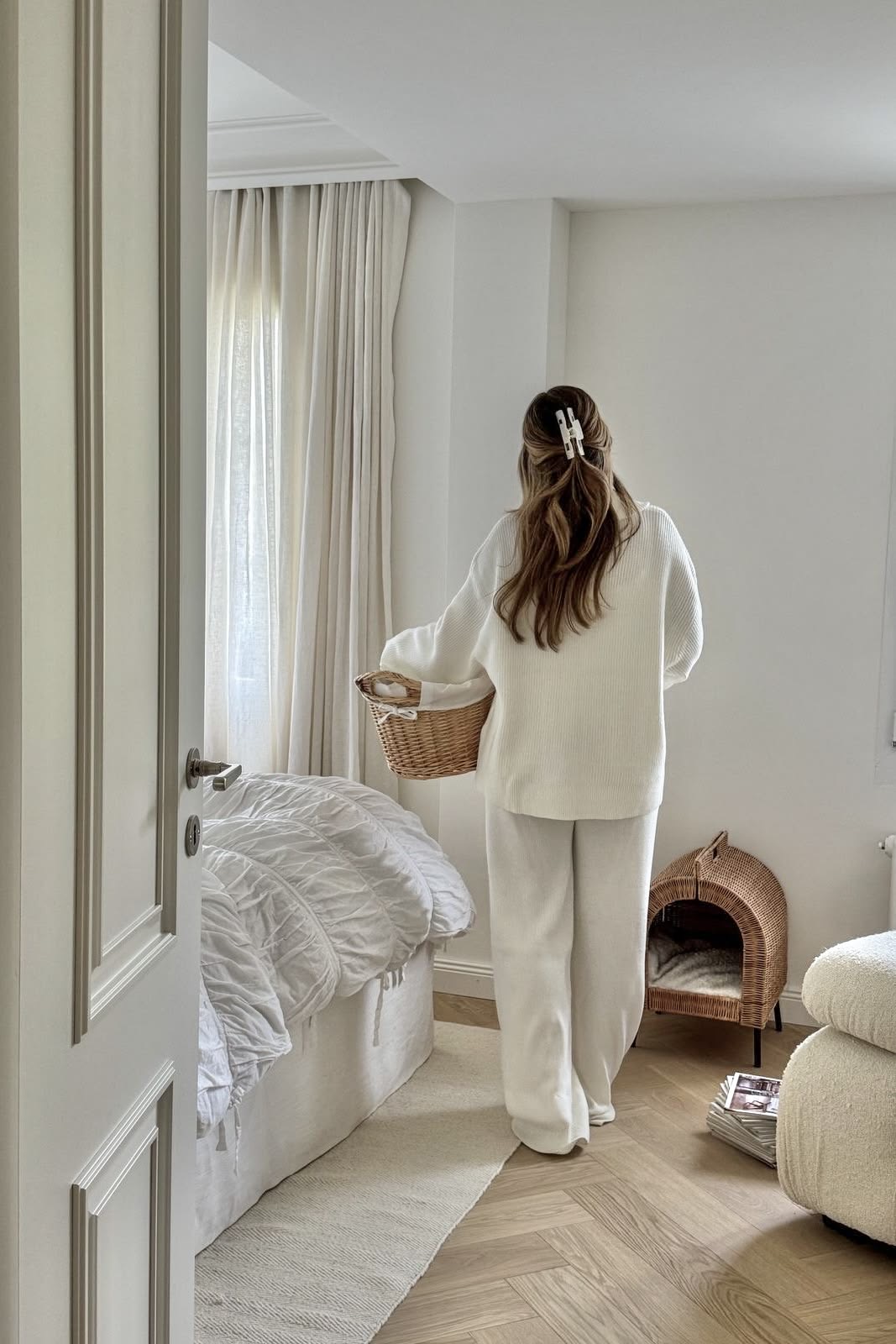 Mulher carregando cesto de roupas pelo quarto